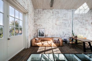 A low-slung, tan leather sofa and the informal, bench-style table with vintage folding chairs work with the relaxed ambiance of the space.