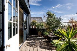Painted in the same warm navy as the exterior walls, the two solid-wood living room doors create a seamless link between the living room and terrace.