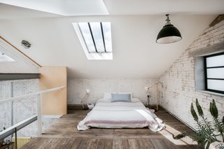 The floor-level bed makes best use of the space in the mezzanine-level bedroom. Luxury additions include recessed Crittall windows and two large skylights, which bring light streaming into the space.