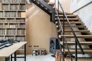The staircase is perfectly designed for its industrial setting, with solid metal banisters and side rails and chunky, wooden open treads.