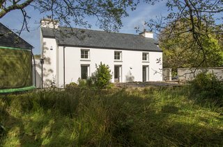 This part of the white stucco house has been rebuilt in the style of the original estate cottage.