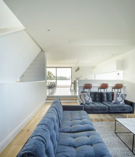 Although this living space is open to the open-plan kitchen/dining area, the change in levels between the two rooms makes it feel like two separate spaces.