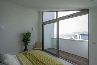 You can hear and see the ocean from this bedroom, which features a covered terrace and full-length glazed sliding doors and a window above.