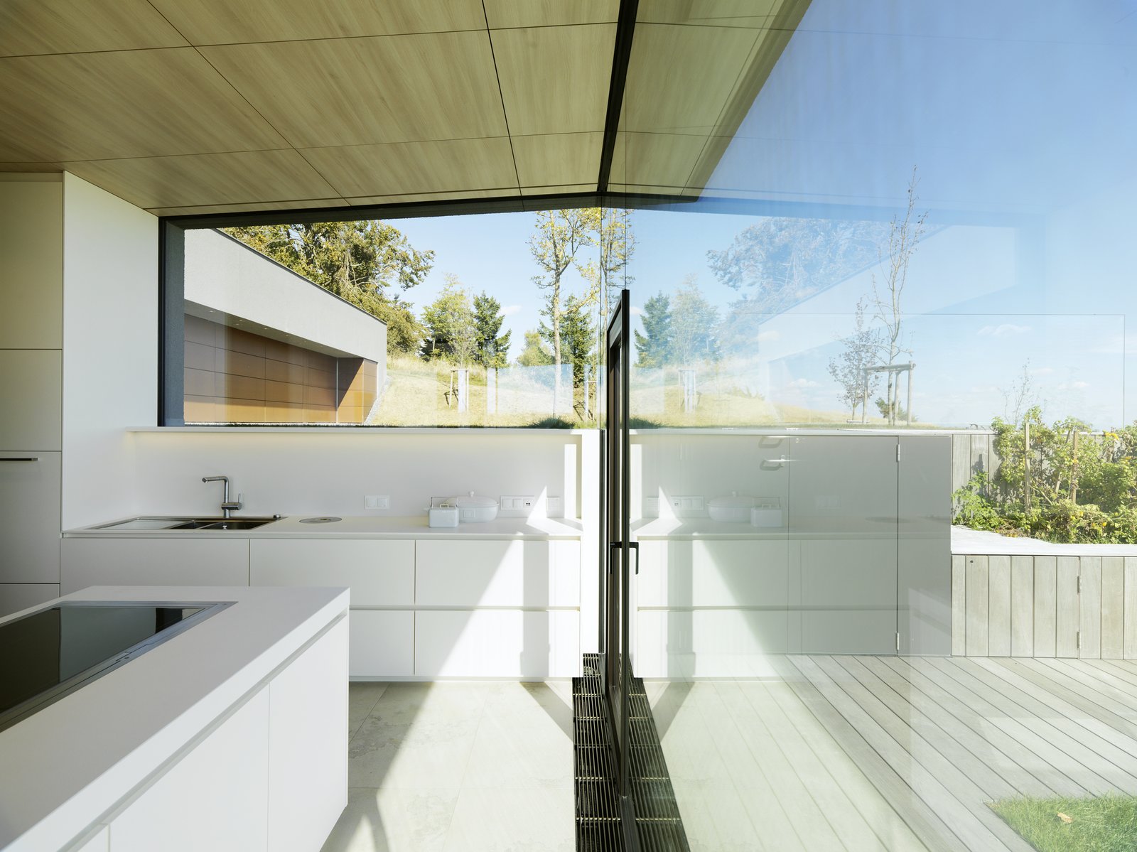 In the private living area on the upper floor, the master bedroom and bath face a secluded atrium, surrounded by Sky-Frame sliding doors.
