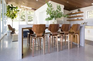Resting on casters, a white oak island nestles under the quartz island in kitchen.
