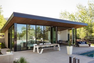 The bi-fold glass wall opens up to, and celebrates, the pool house's natural setting.