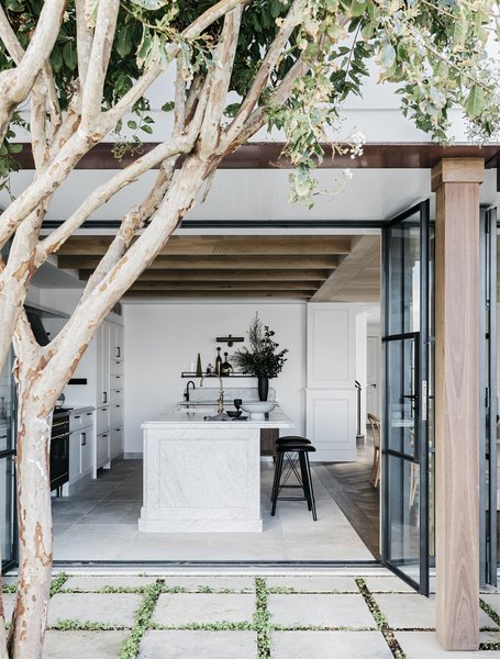 The kitchen now opens out to a courtyard and outdoor dining area thanks to large glass doors.