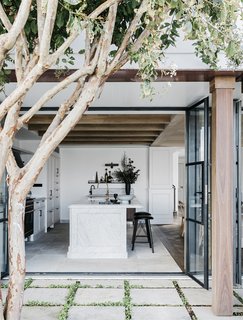 The kitchen now opens out to a courtyard and outdoor dining area thanks to large glass doors. 