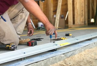 A worker installs Marvin Windows and Doors. "We wanted to have the ability as much as possible to open to the outside, so using the Marvin Contemporary Studio line was really essential," says Turkel.