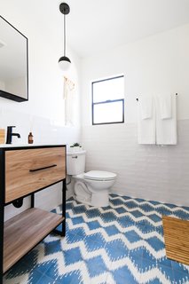A combination of crisp white walls and funky floor tile lends big personality to this bathroom.
