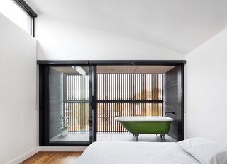 Bedroom, Medium Hardwood Floor, Ceiling Lighting, and Bed A Balcony With a Bathtub Caps This Striking Prefab in Melbourne - Photo 9 of 17 - 