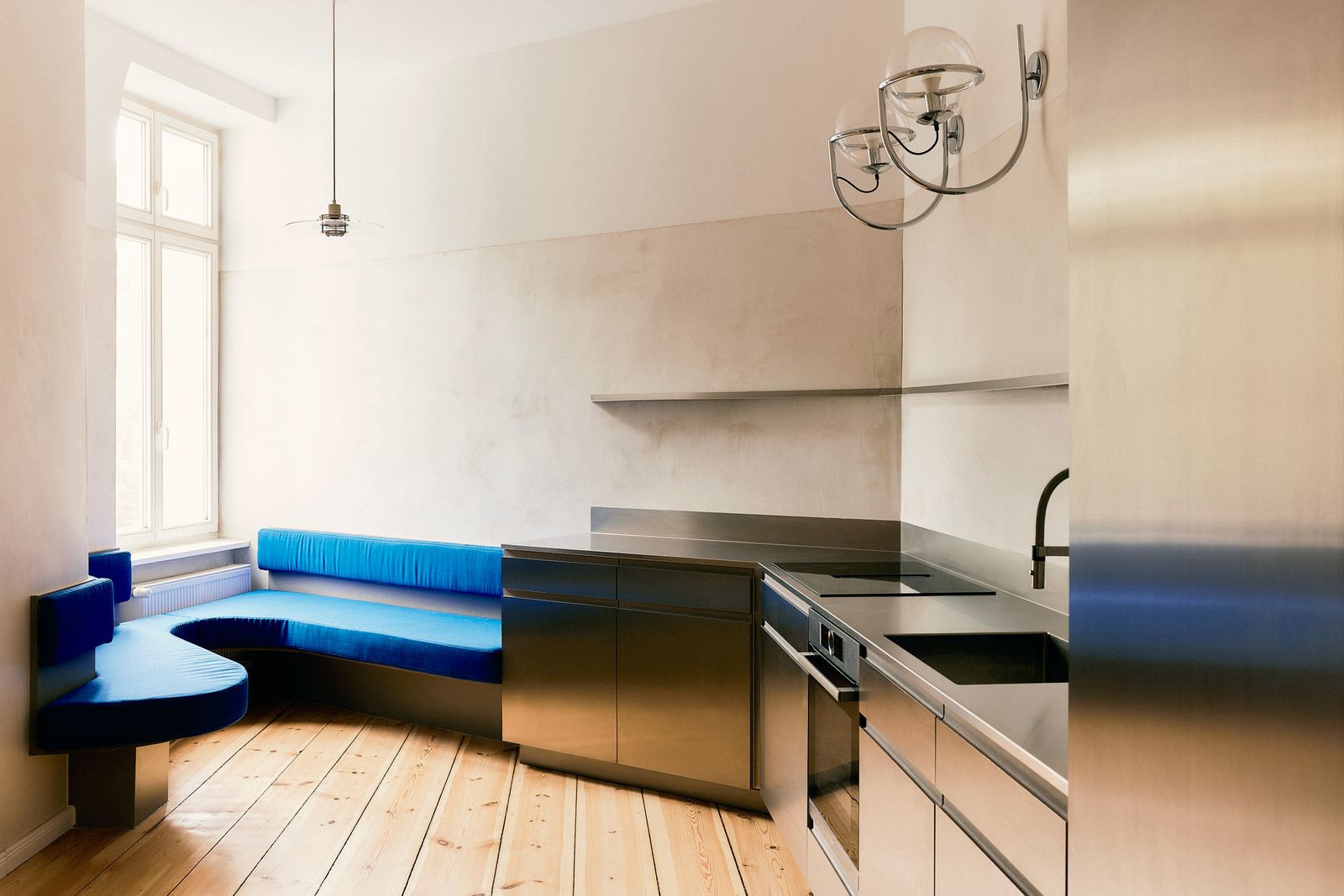 A Curvy Blue Banquette Solves a Tiny Berlin Apartment’s Puzzling Shape