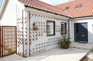 Trellises With Cor-Ten Cutouts Wrap the Facade of This Renovated U.K. Home